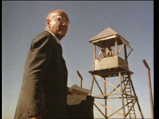 Photo copyright: Weis Films. Man in front of a guard tower.